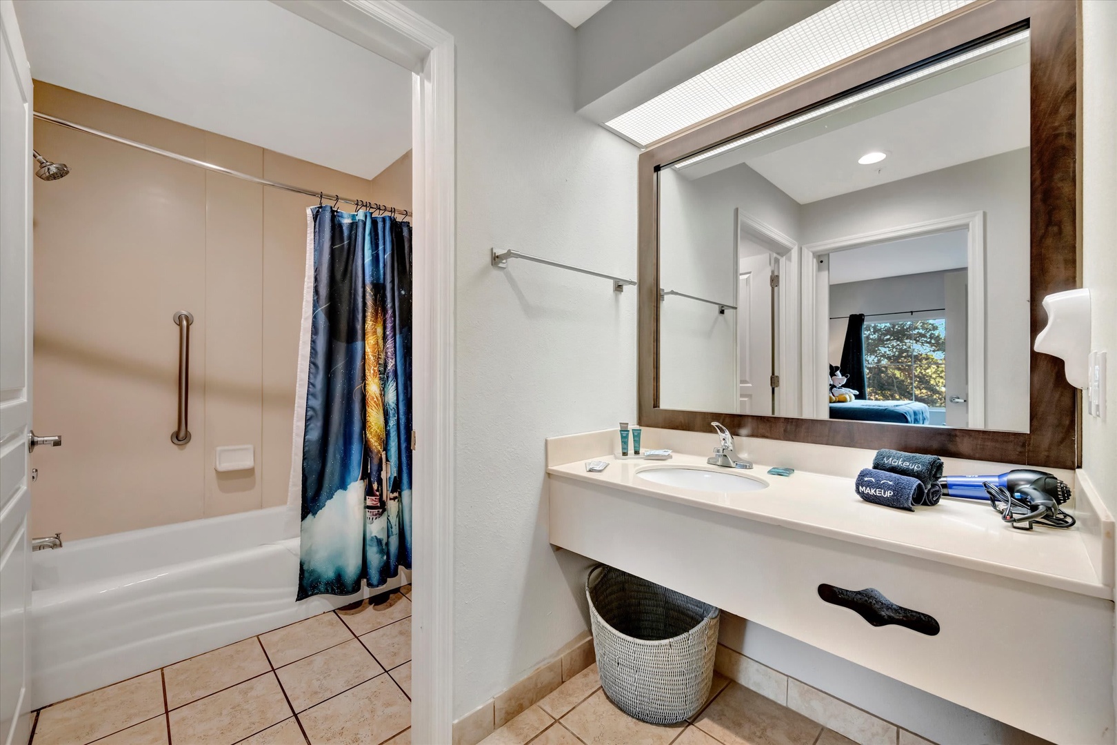 Freshen up in your bright private bathroom, featuring a spacious vanity and full tub with convenient grab bars for added comfort and safety.