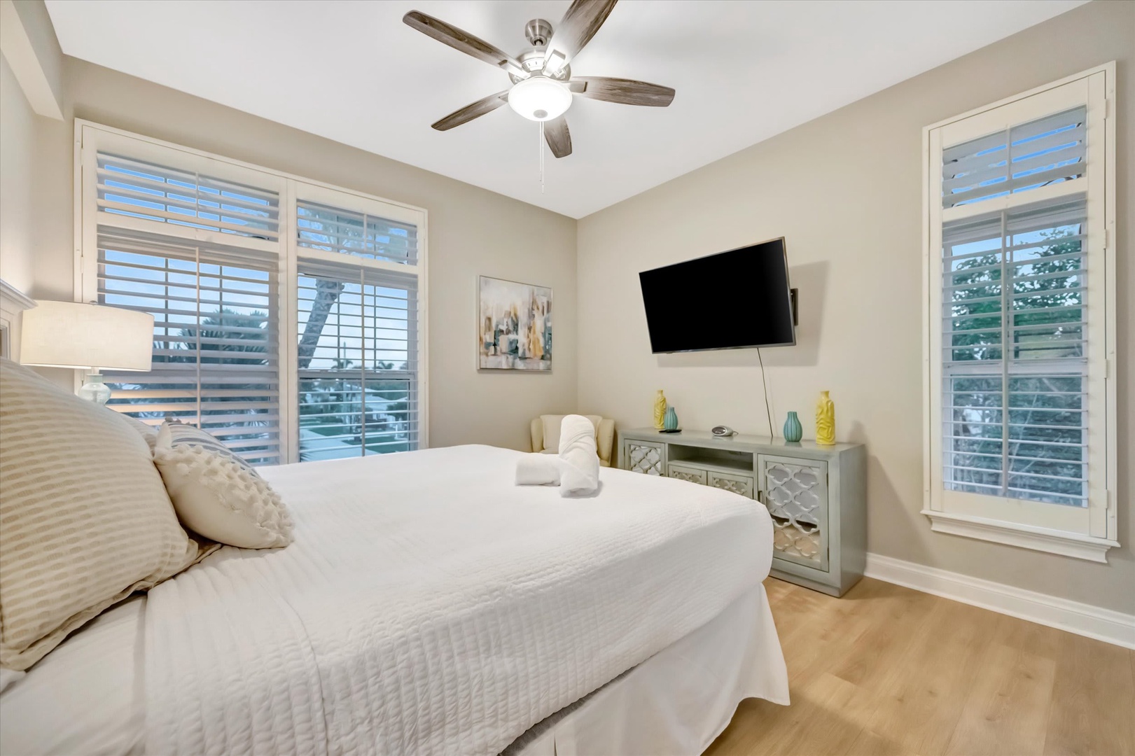 Settle into crisp linens and wake to gentle breezes under your ceiling fan. Natural light fills your serene retreat, where coastal-inspired décor creates a calming escape.