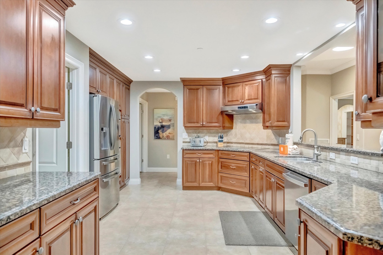 Step into this bright, open kitchen with rich wood cabinetry and gleaming granite countertops. You'll love preparing meals with plenty of space and modern stainless steel appliances at your fingertips.