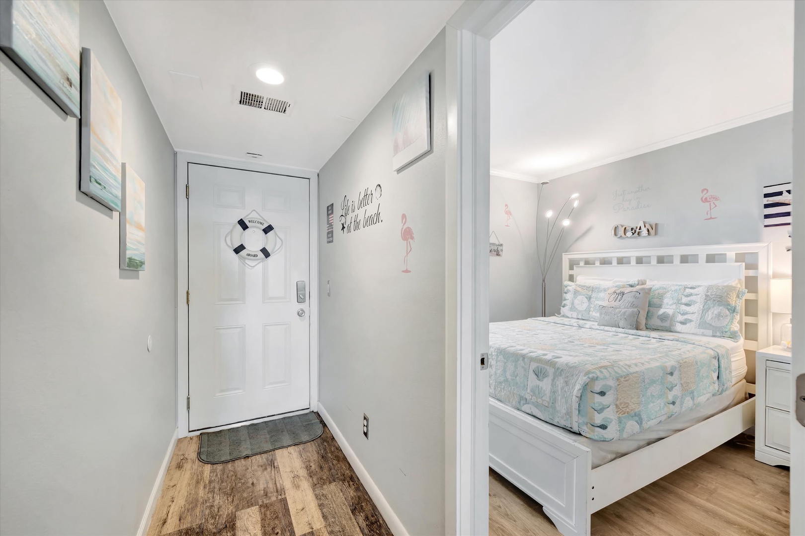 Step inside to find bright coastal charm with beach-themed decor welcoming you into a cozy bedroom with coastal touches and wood-style flooring throughout.