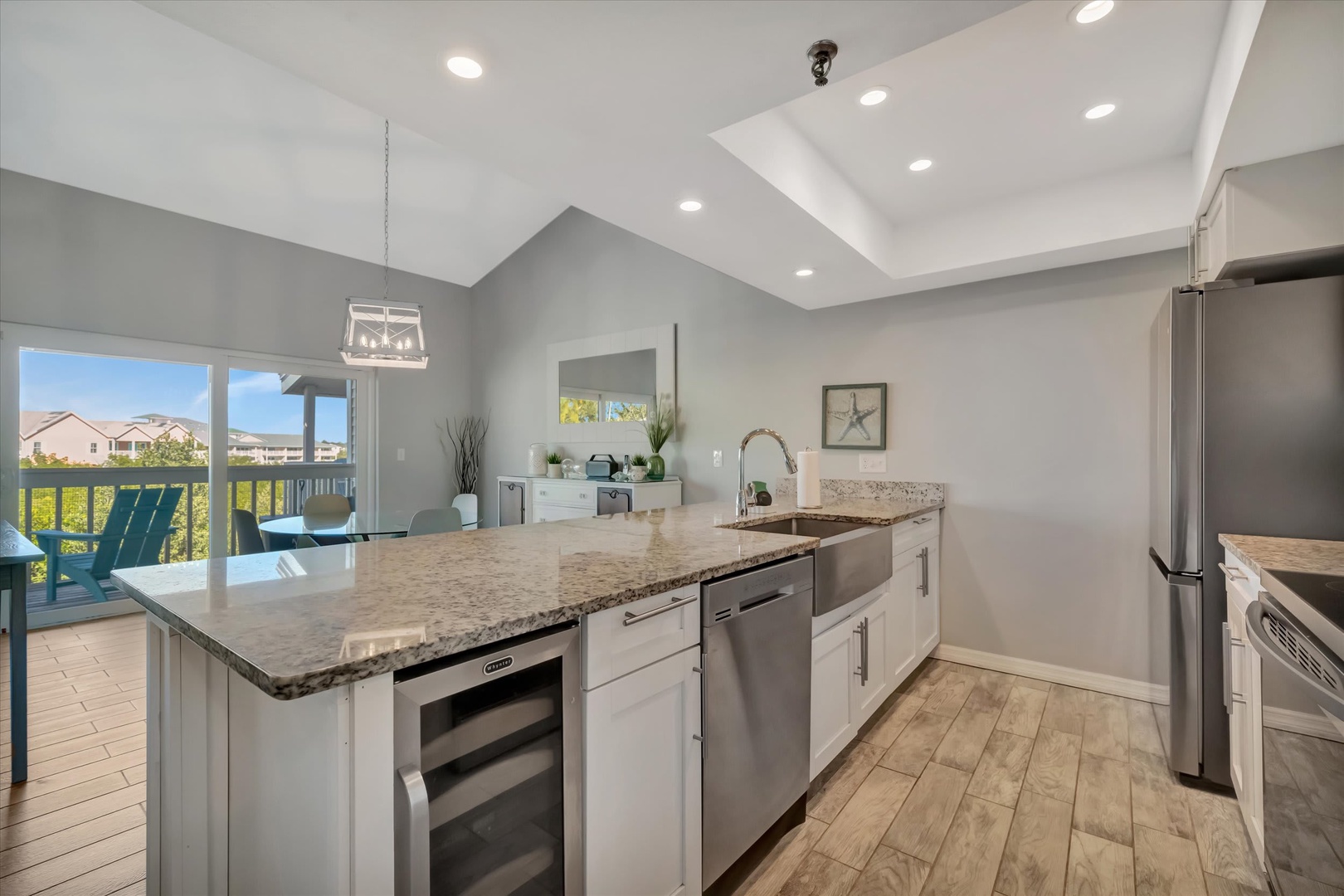 Your fully equipped modern kitchen opens to your private deck, where you can enjoy morning coffee surrounded by neighborhood views. High ceilings and natural light create a bright, open space perfect for preparing meals during your stay.