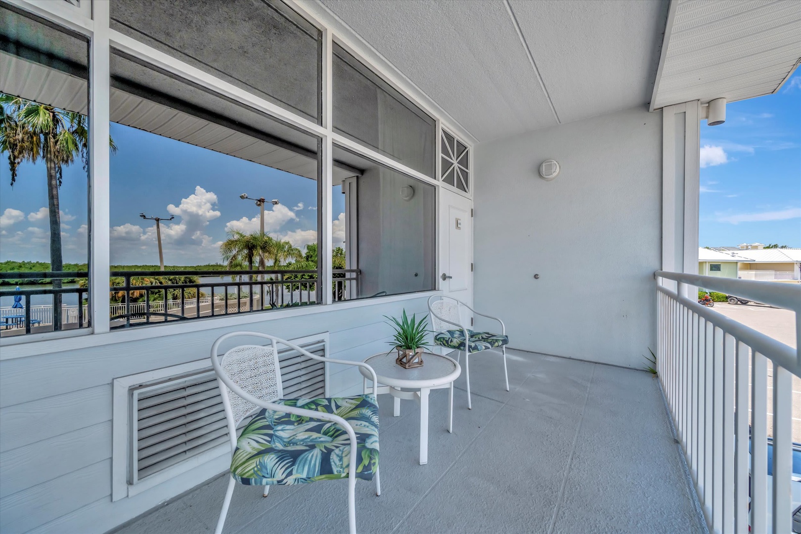 Step out to your private covered balcony and relax with serene water views, framed by tropical palms and a refreshing breeze. Your peaceful retreat awaits just outside the door.