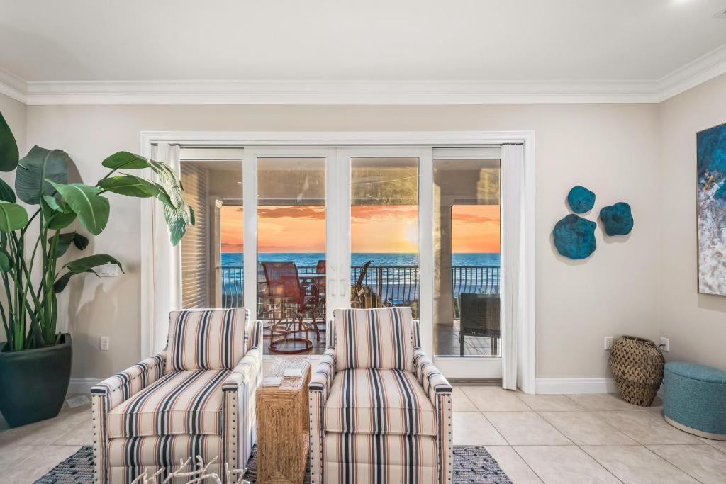 Settle into your private retreat where coastal elegance meets comfort. Two plush armchairs invite you to unwind while taking in stunning sunset views over the sparkling ocean from your private balcony.