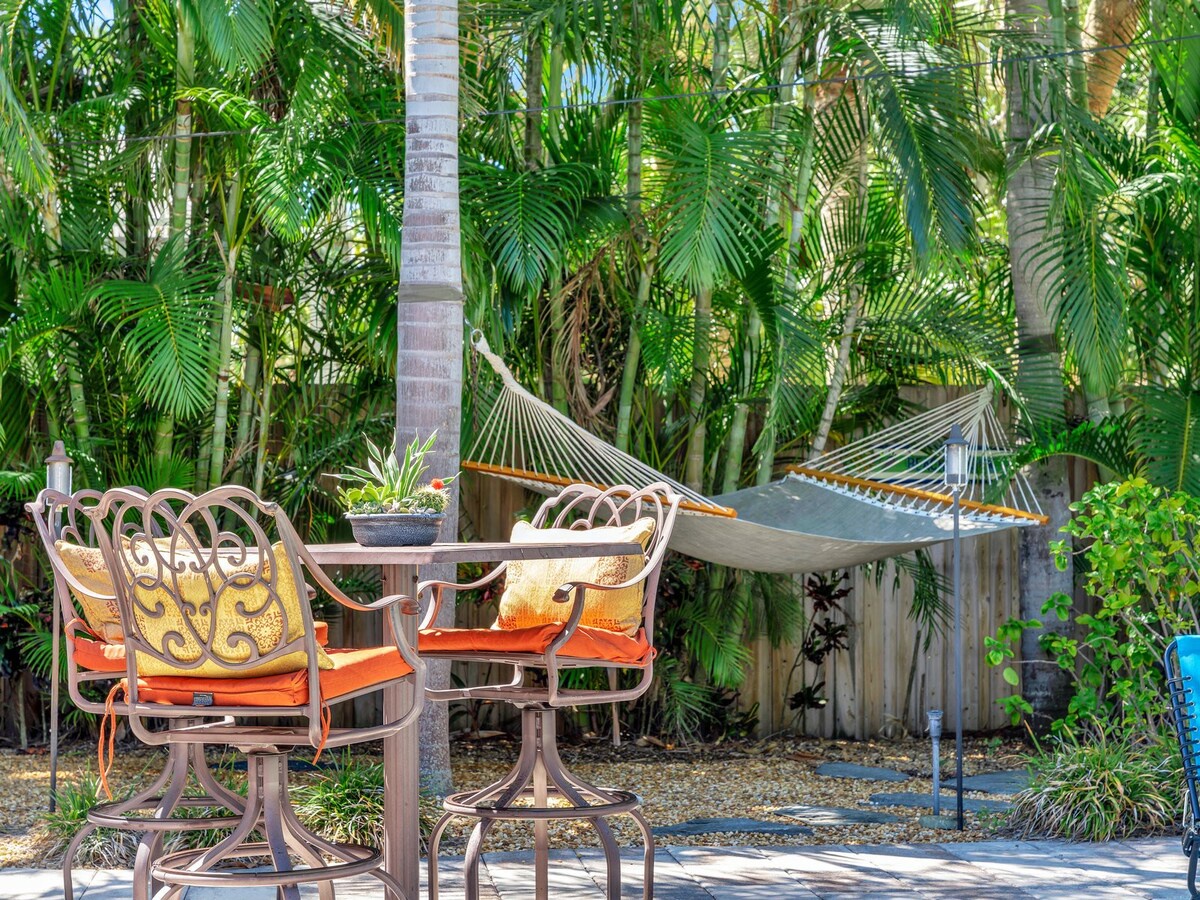 Escape to your private tropical oasis, where a shaded hammock and cozy seating await beneath swaying palms—your perfect spot to unwind with a morning coffee or afternoon read.