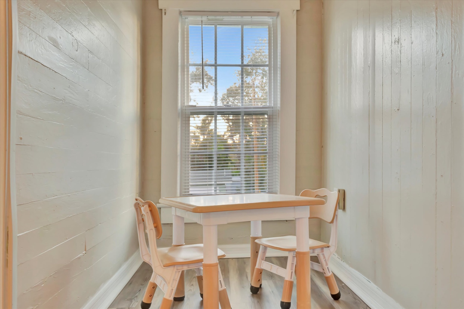 A sunlit nook invites you to enjoy morning coffee or play games at your private table for two, with natural light streaming through the window.