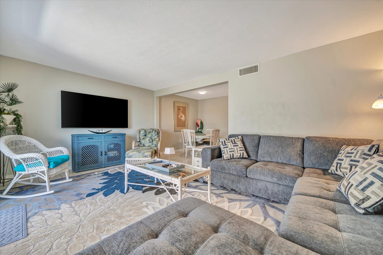Relax in your bright, spacious living room with a plush sectional sofa, coastal-inspired décor, and a welcoming open layout perfect for unwinding after beach days.