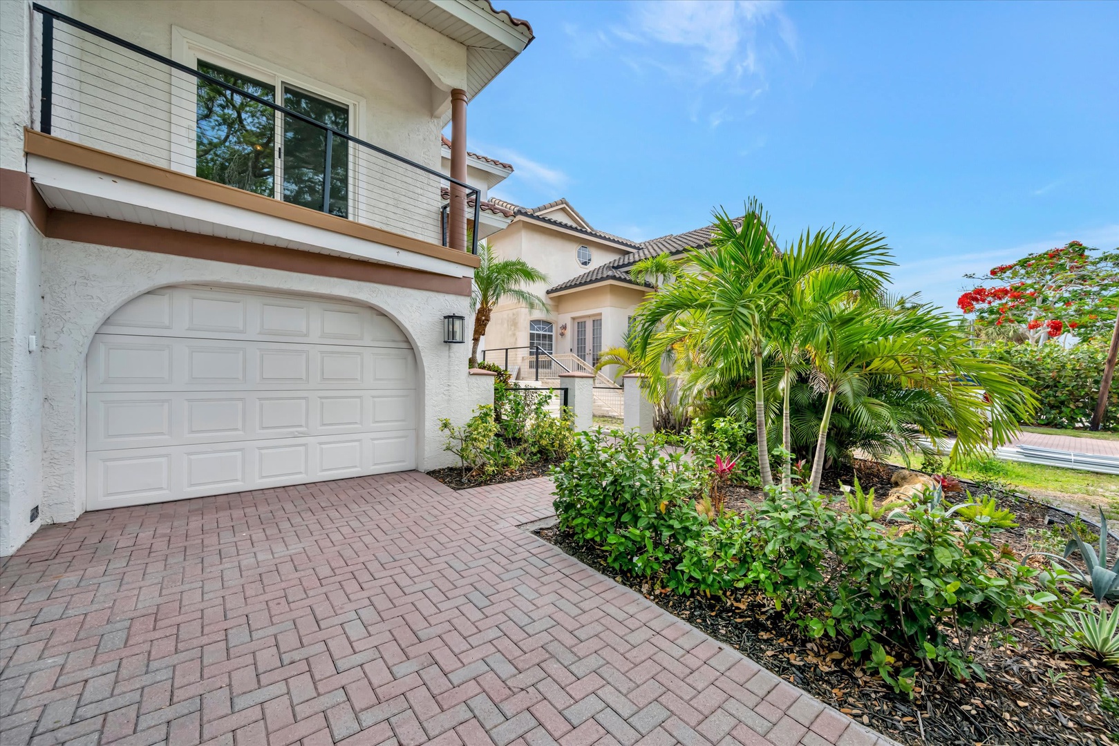 Arrive at a beautifully maintained property surrounded by lush tropical landscaping, with convenient garage parking and bright, welcoming architecture setting the stage for a relaxing stay.