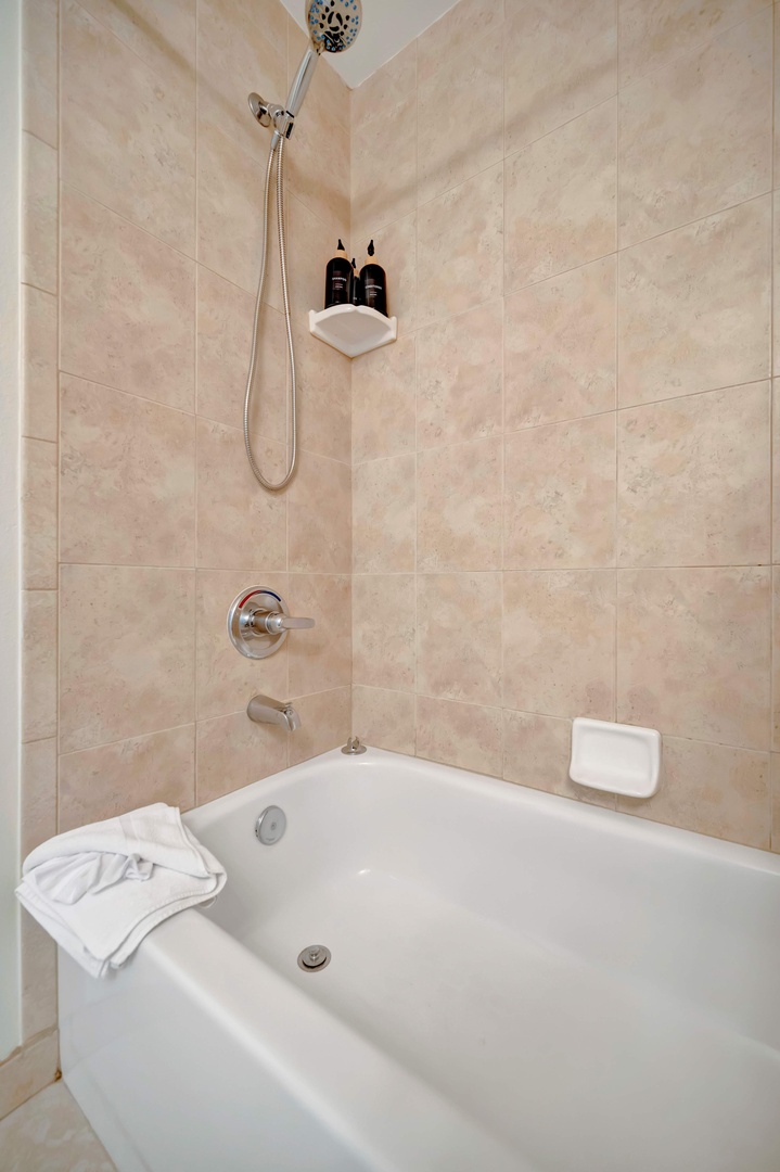 Step into your private spa retreat with a deep soaking tub and soothing rainfall shower. Elegant travertine tiles set the tone for total relaxation.