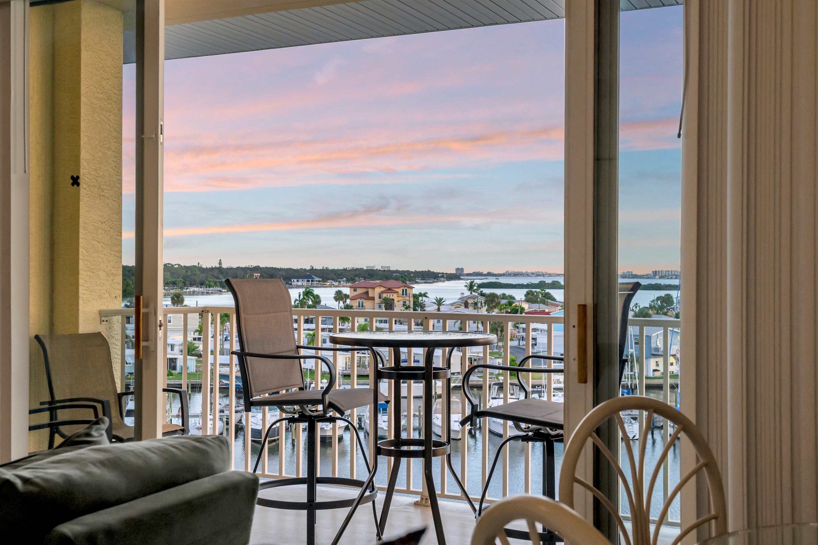 Step out onto your private balcony and soak in stunning water views framed by a colorful evening sky—perfect for unwinding with a drink after a day of exploring.