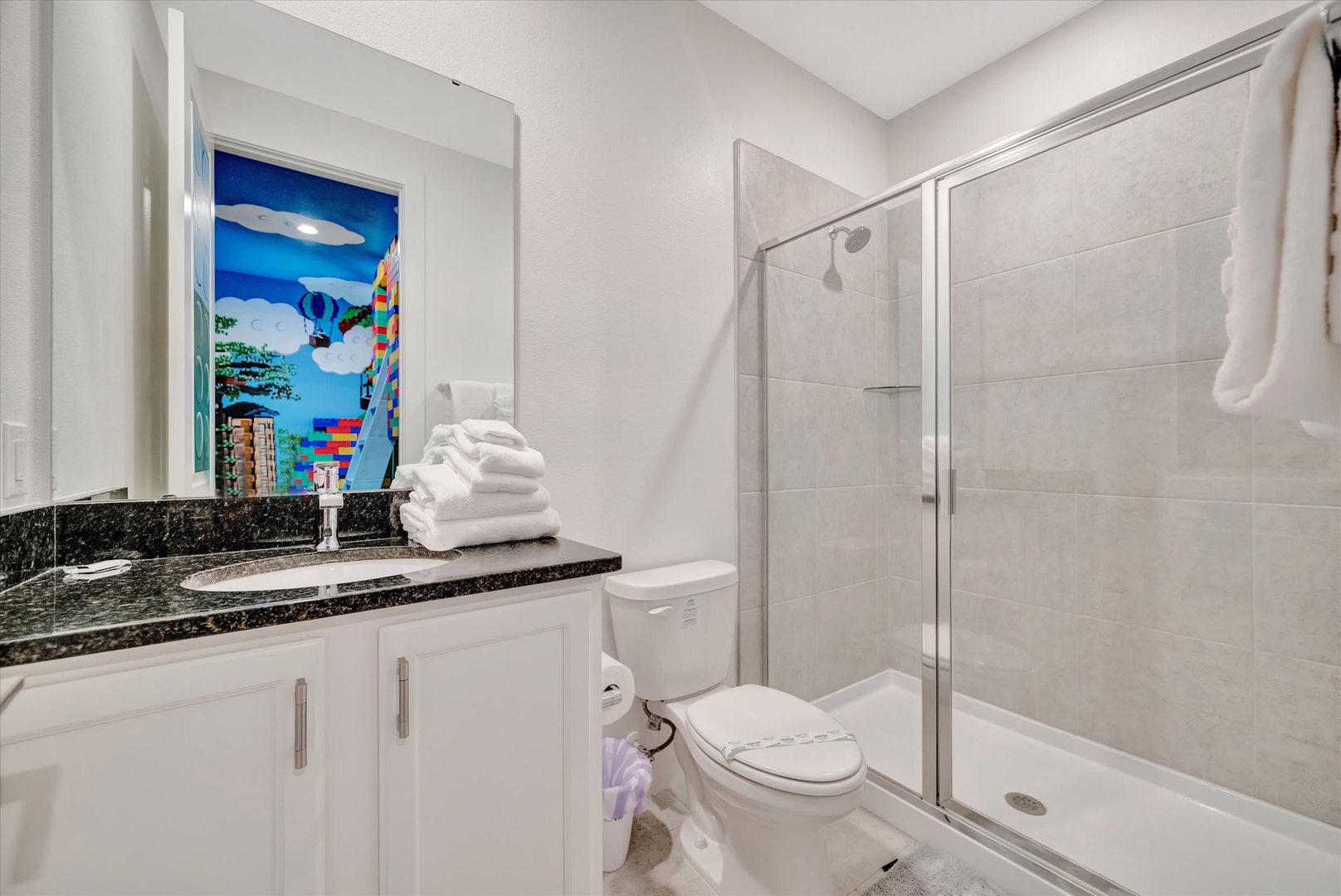 Step into a spotlessly clean bathroom with fresh towels waiting for you, a sleek glass-enclosed shower, and elegant granite countertops—your private retreat for unwinding after a day of adventure.