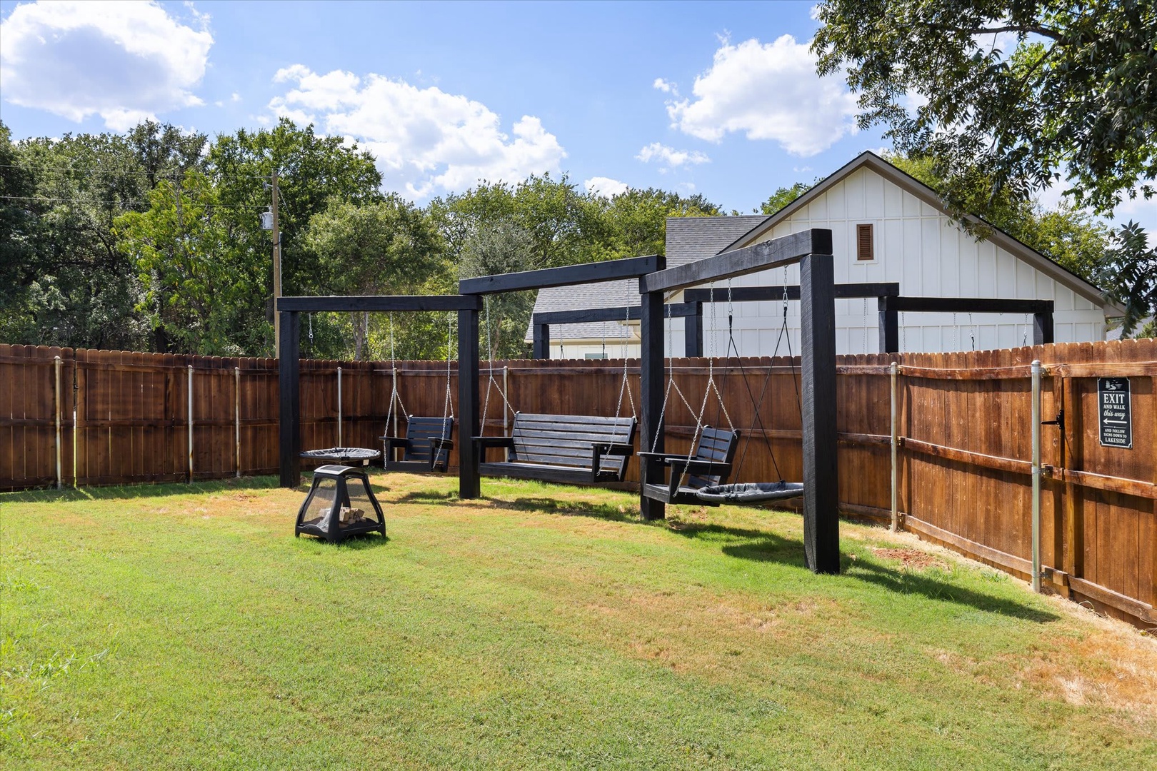 Step outside to your private backyard retreat where three swing benches invite you to sway under the open sky. Fire up the grill for an evening cookout, then gather under the stars in this serene, fenced outdoor space.