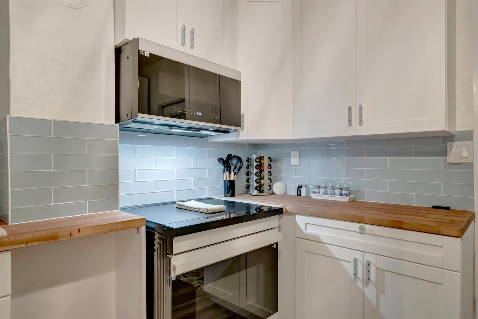 Picture yourself cooking in this bright, modern kitchen, complete with sleek appliances, warm wood countertops, and ample cabinet space for everything you need.