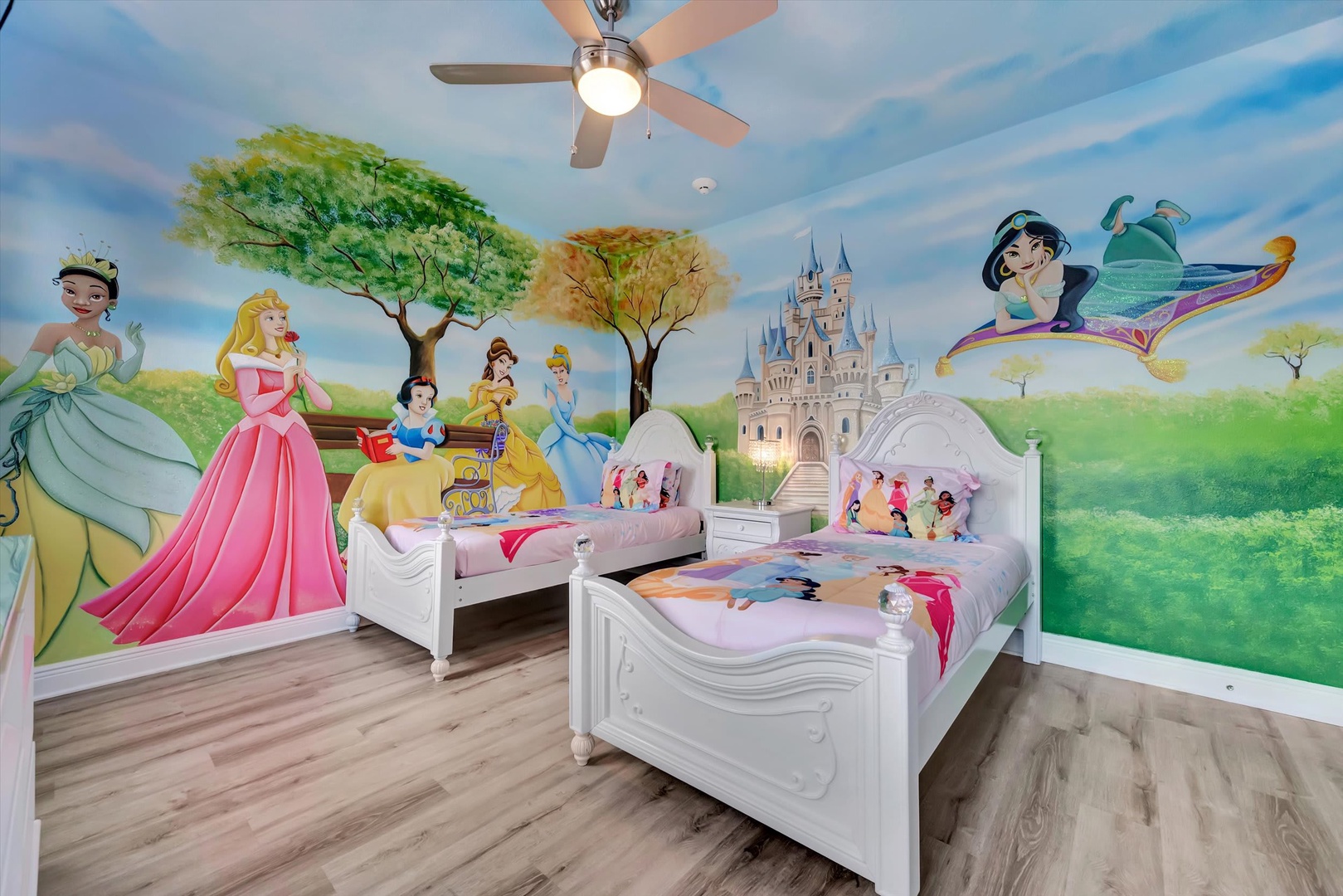 This enchanting themed bedroom features twin beds, ceiling fan, and a whimsical mural transforming the space into a magical storybook setting for your little ones.