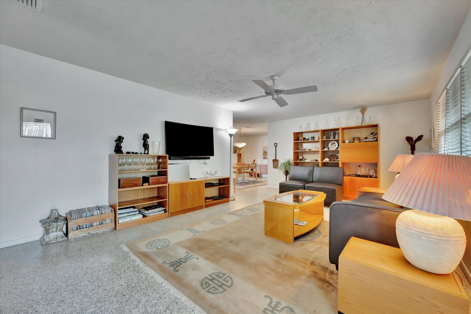 Sink into modern comfort in your spacious living room, where sleek furniture, warm lighting, and a ceiling fan create the perfect retreat after a day of exploring.
