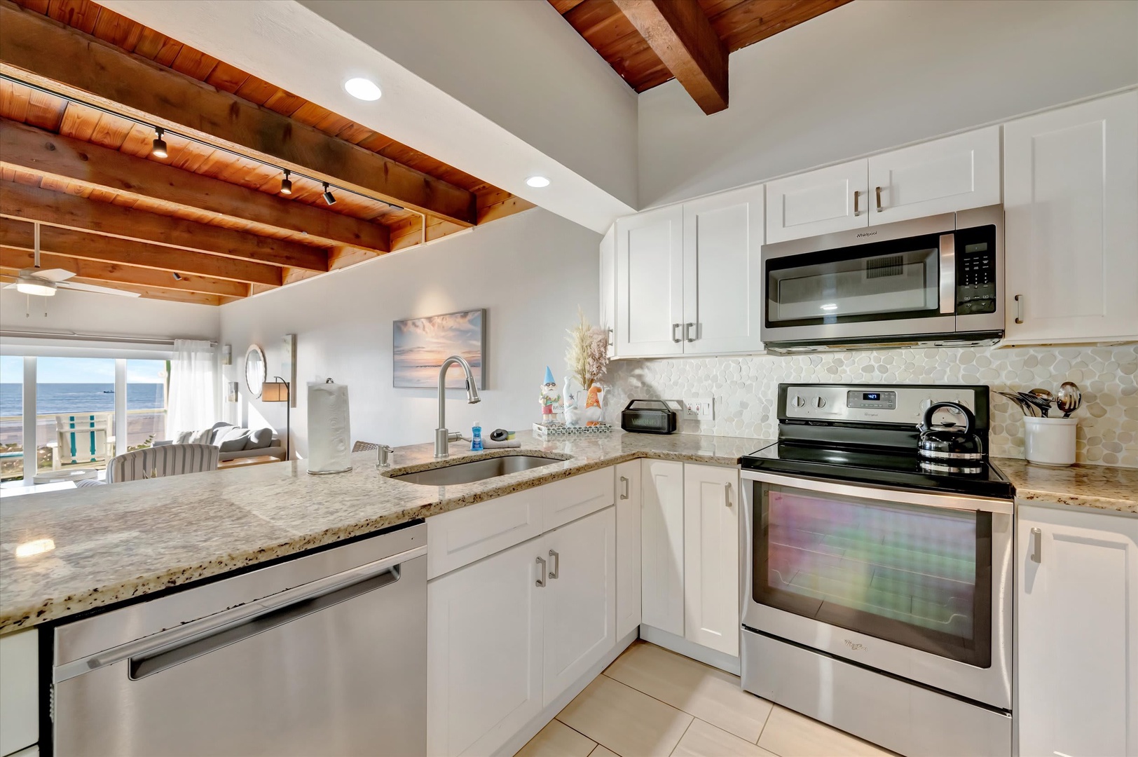 Step into your bright, fully equipped kitchen with granite countertops and stainless appliances. Cook while gazing at peaceful ocean views through the windows—pure coastal serenity awaits.