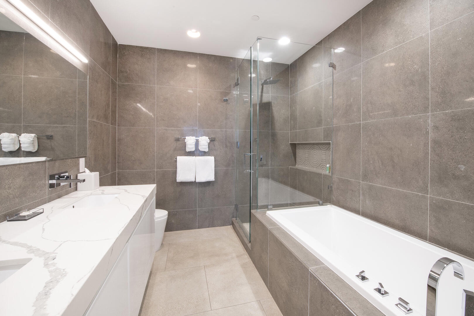 Primary ensuite with dual vanities, bathtub, and separate shower.
