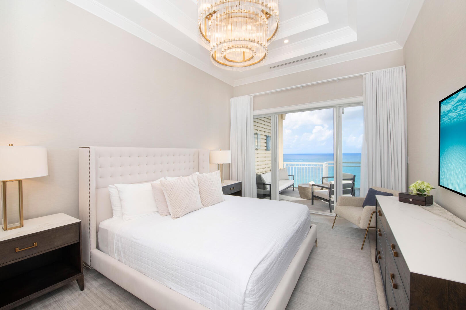 Primary suite with king bed, television, and walkout access to the ocean balcony.