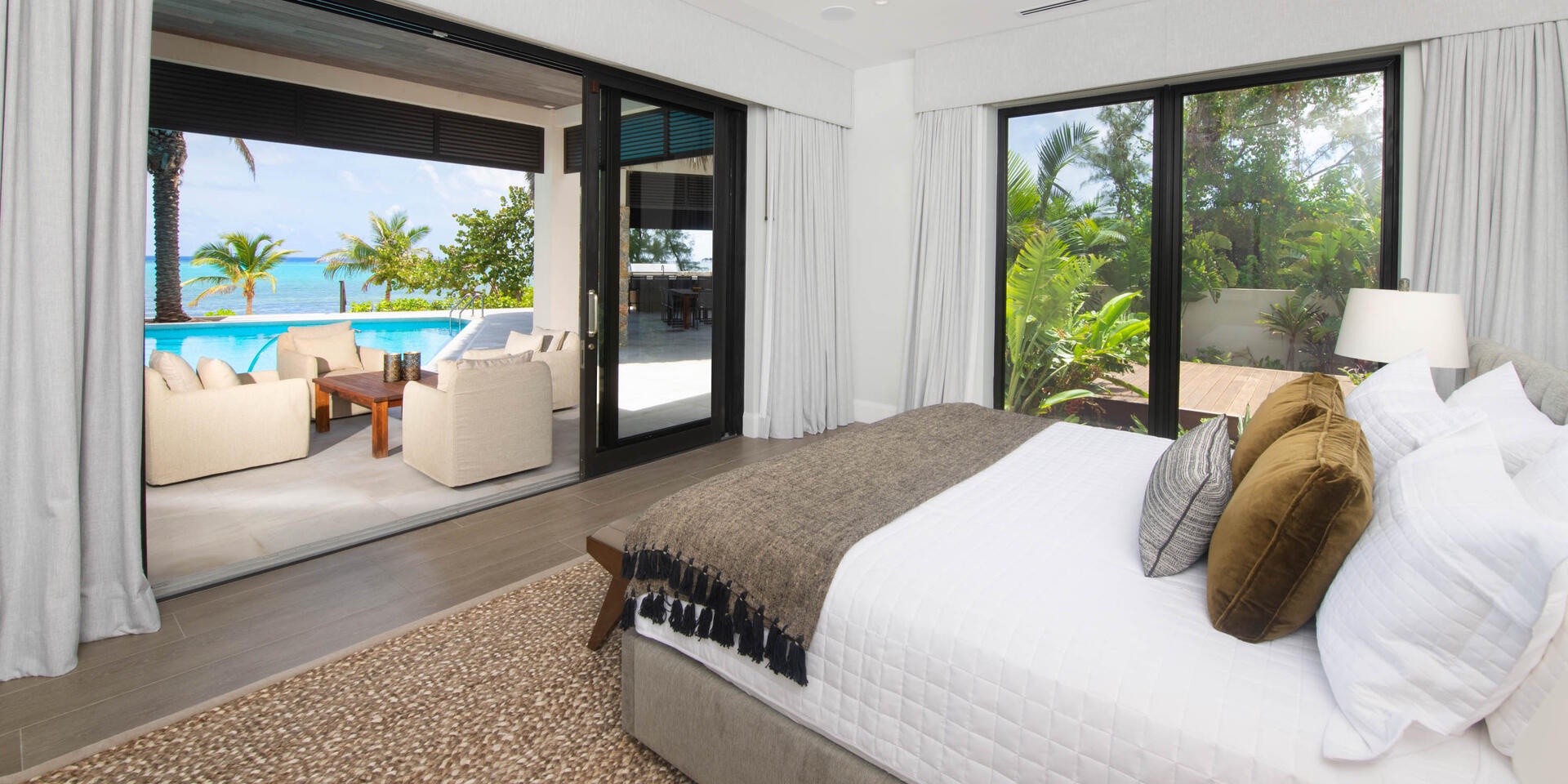 Bedroom 1 is the primary suite on the main villa's lower level with king bed, ocean views, and walkout access to the pool deck.