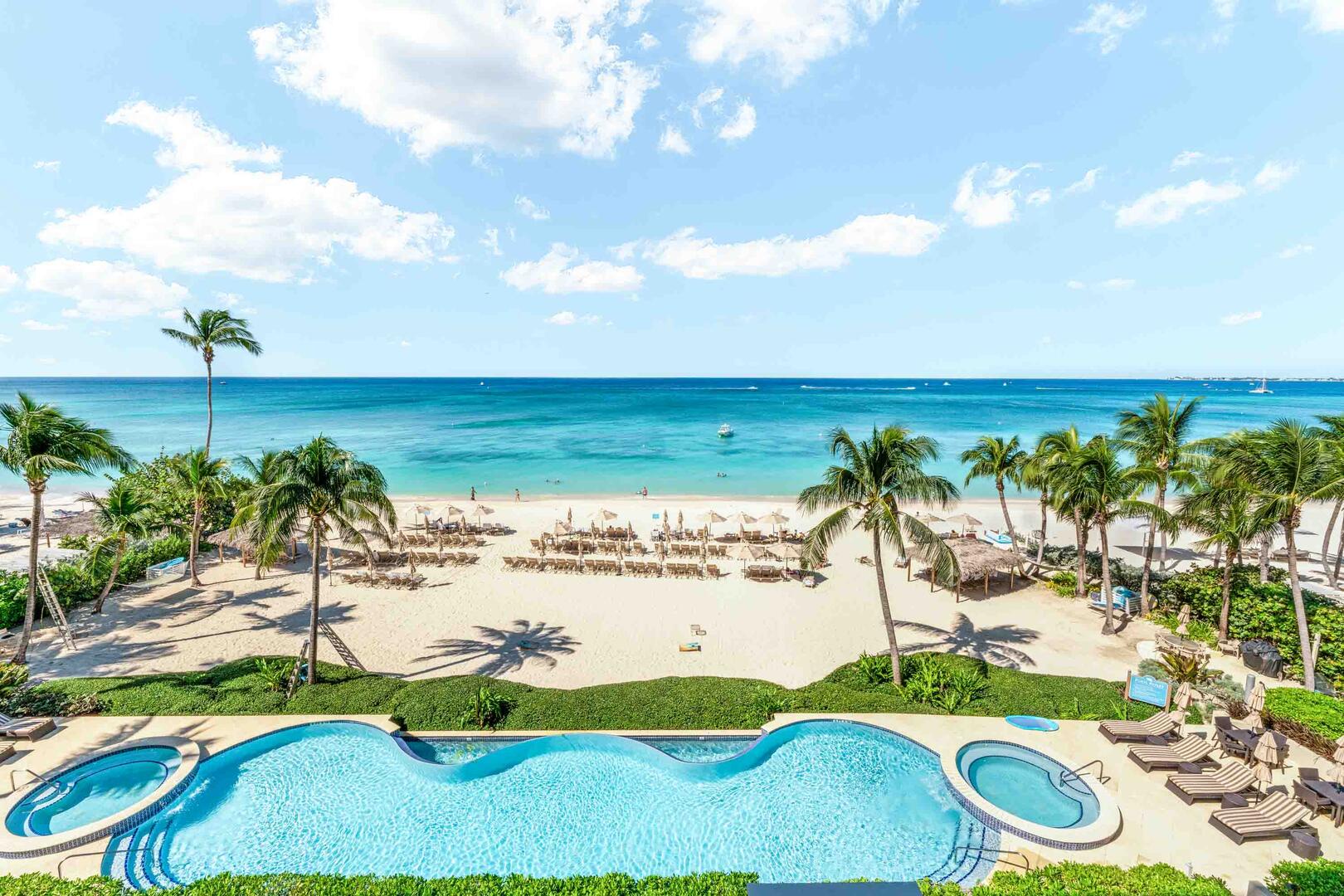 Balcony views overlooking the resort's pool deck and Seven Mile Beach.