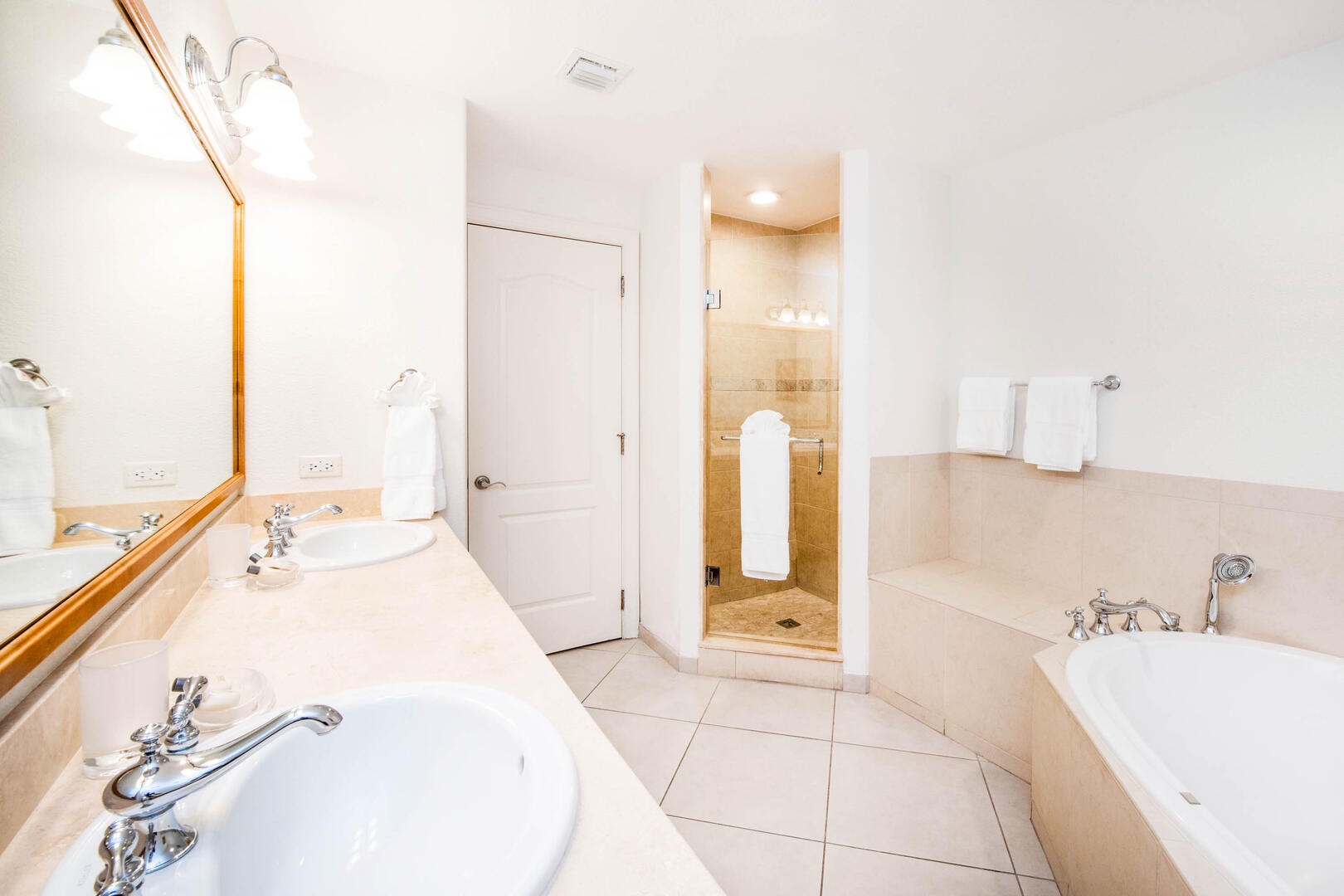 Primary ensuite with dual vanity, large bathtub, and separate shower.