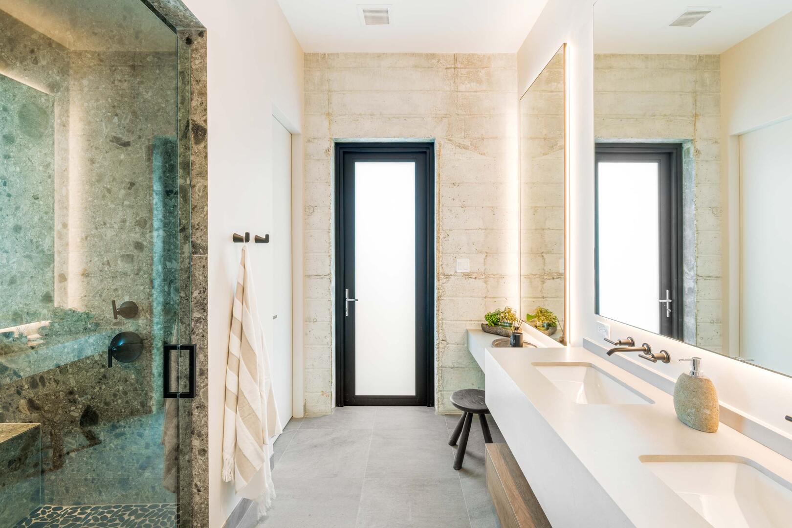 Suite 4 ensuite bathroom with double vanity, multiple mirrors, lighted make-up station, walk-in oceanview shower