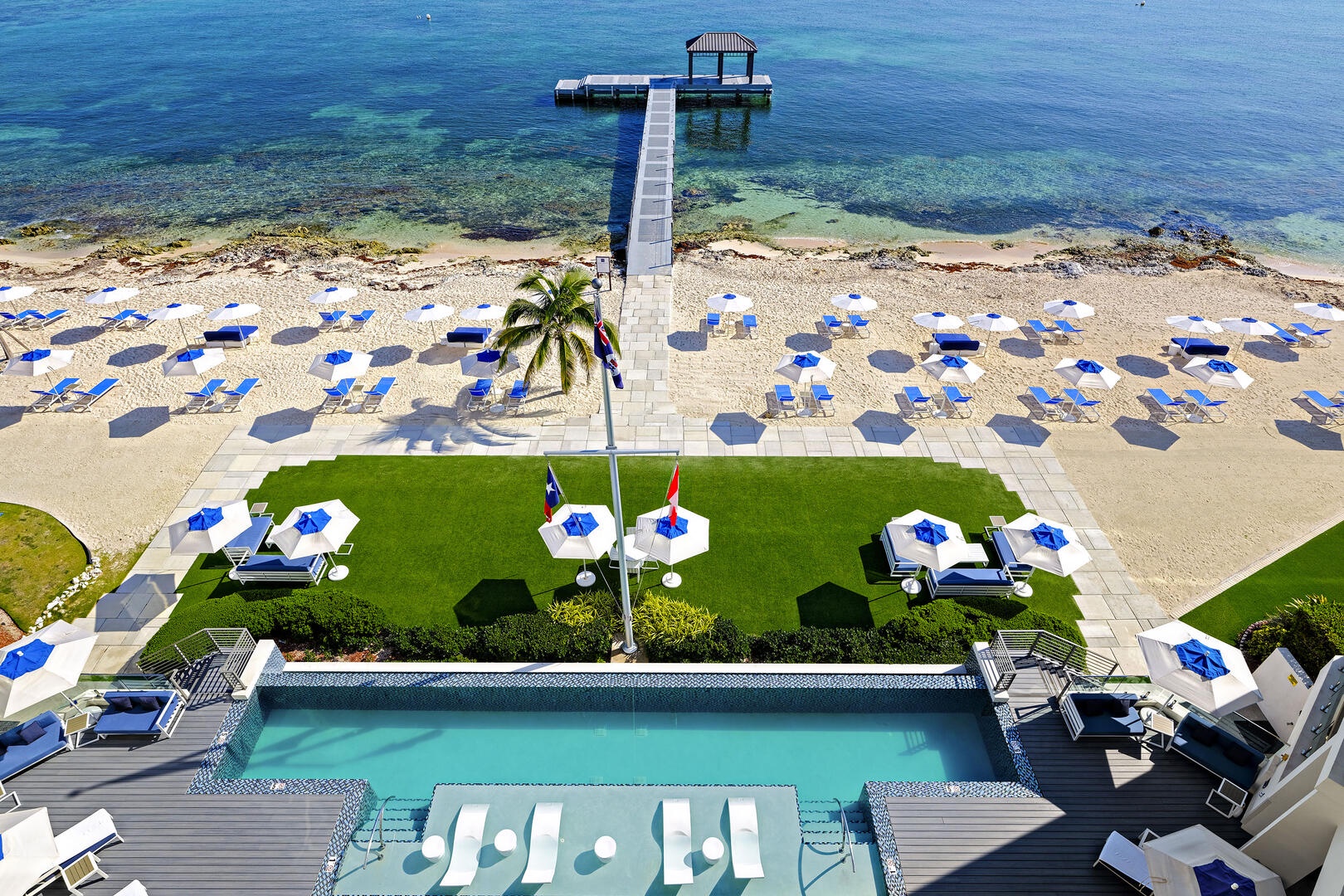 View of the resort's pool deck, beachfront, and dock.