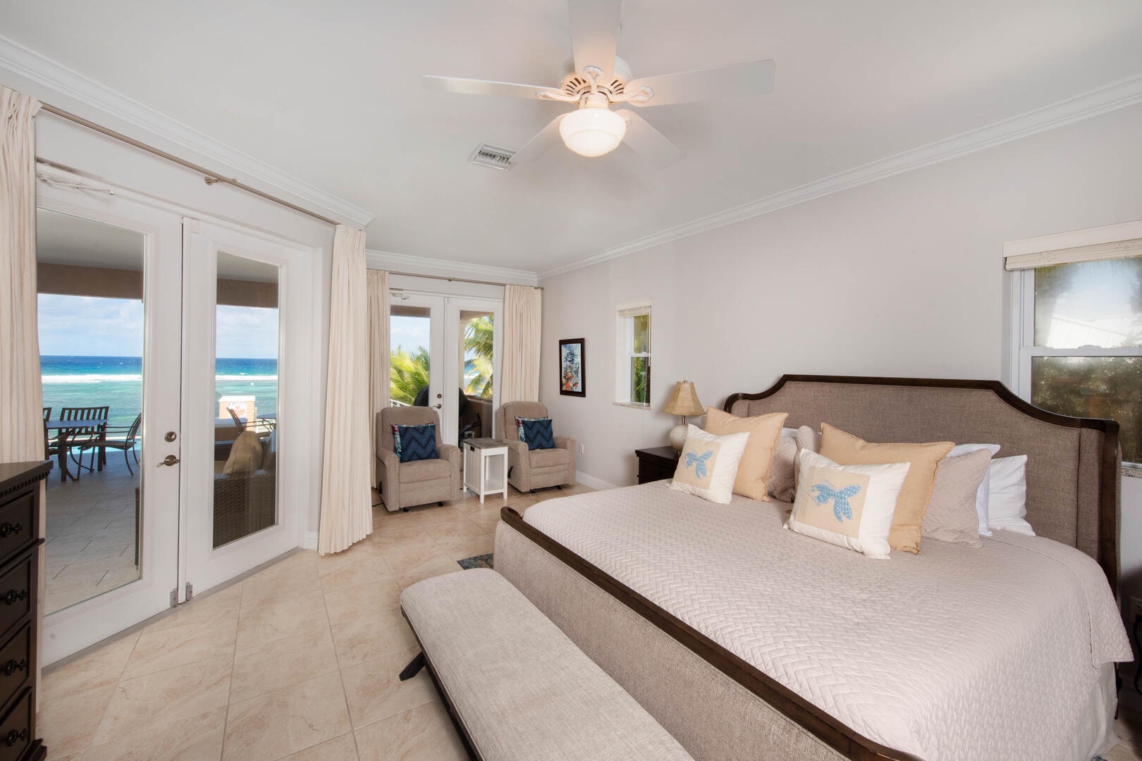 Primary Suite - doors to the pool deck, stunning ocean views, two comfy chairs.