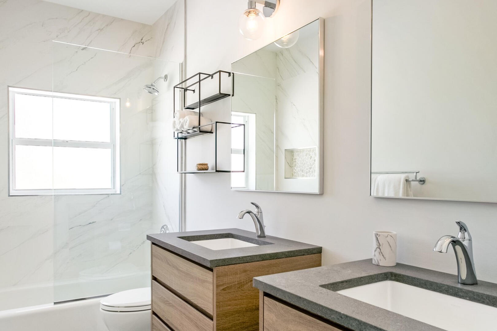 Both lower level bedrooms share this hall bath equipped with dual vanities and a shower bath.