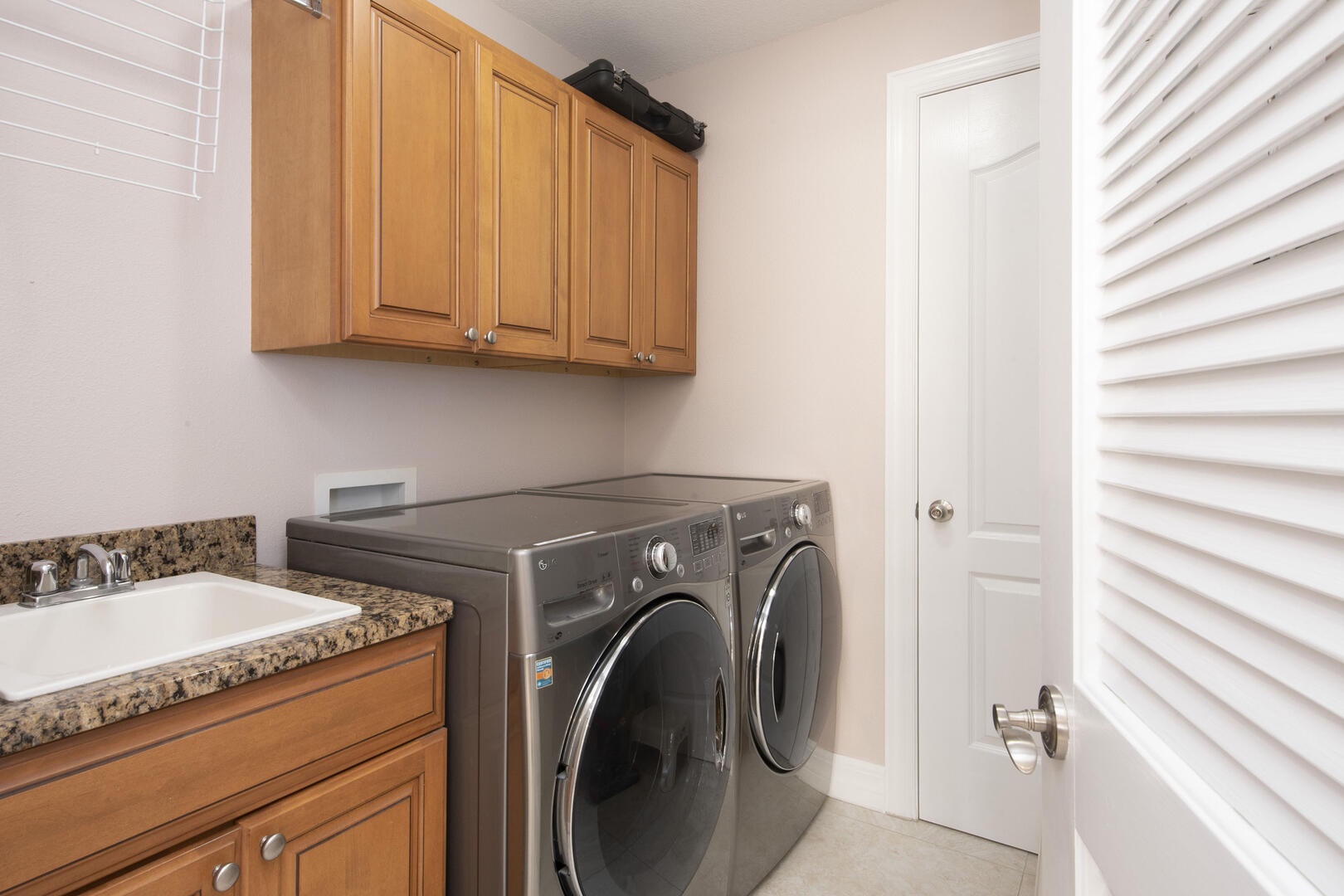 In-unit laundry room with utility sink.