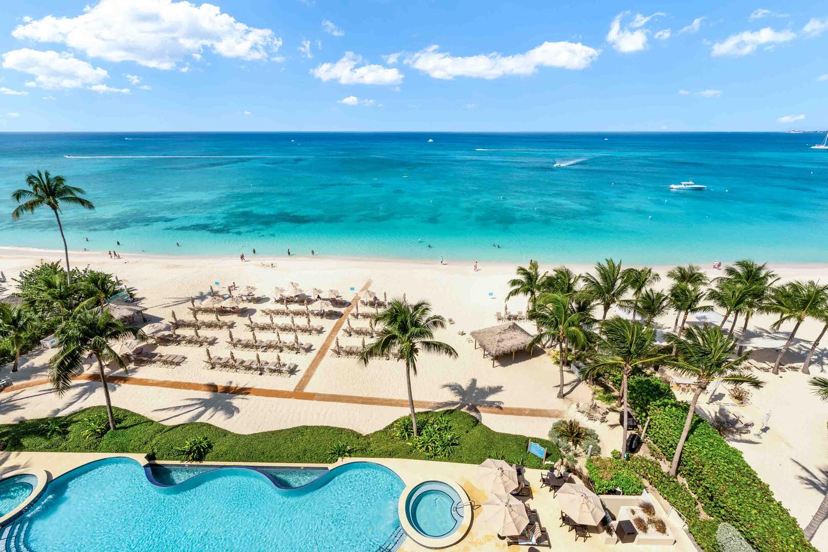 Balcony views of Beachcomber's pool, twin spas, and daily beach service with loungers and sunbrellas.
