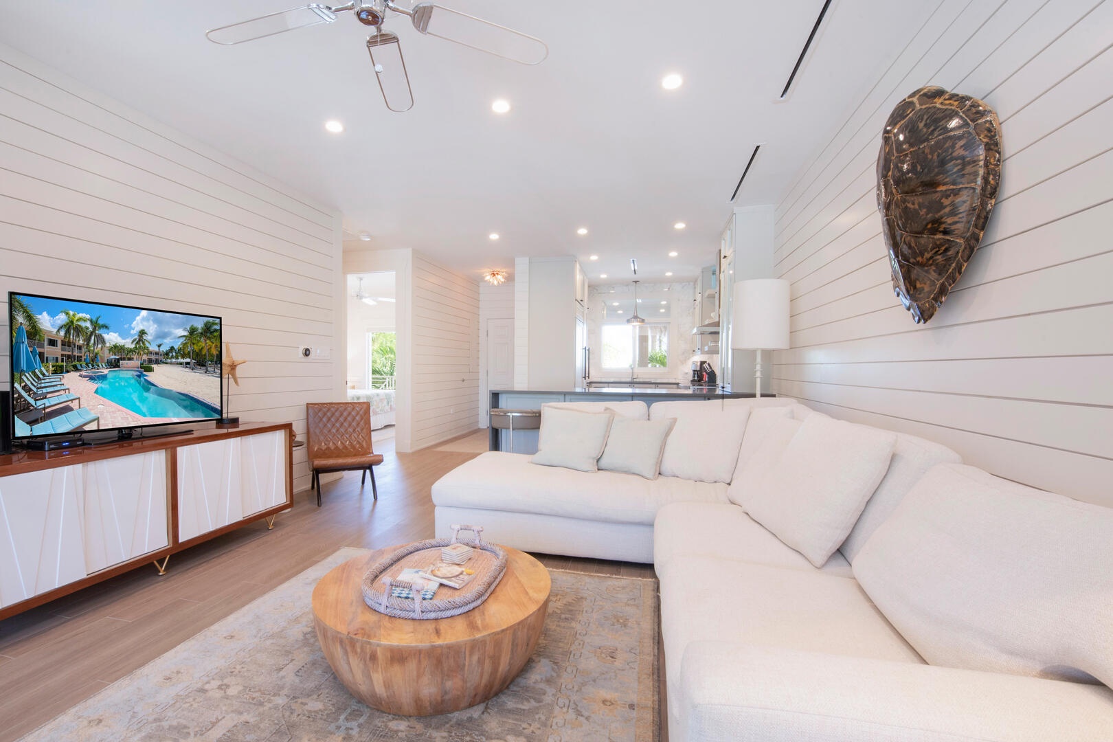 Living area with modern decor, a large sectional sofa, and television.