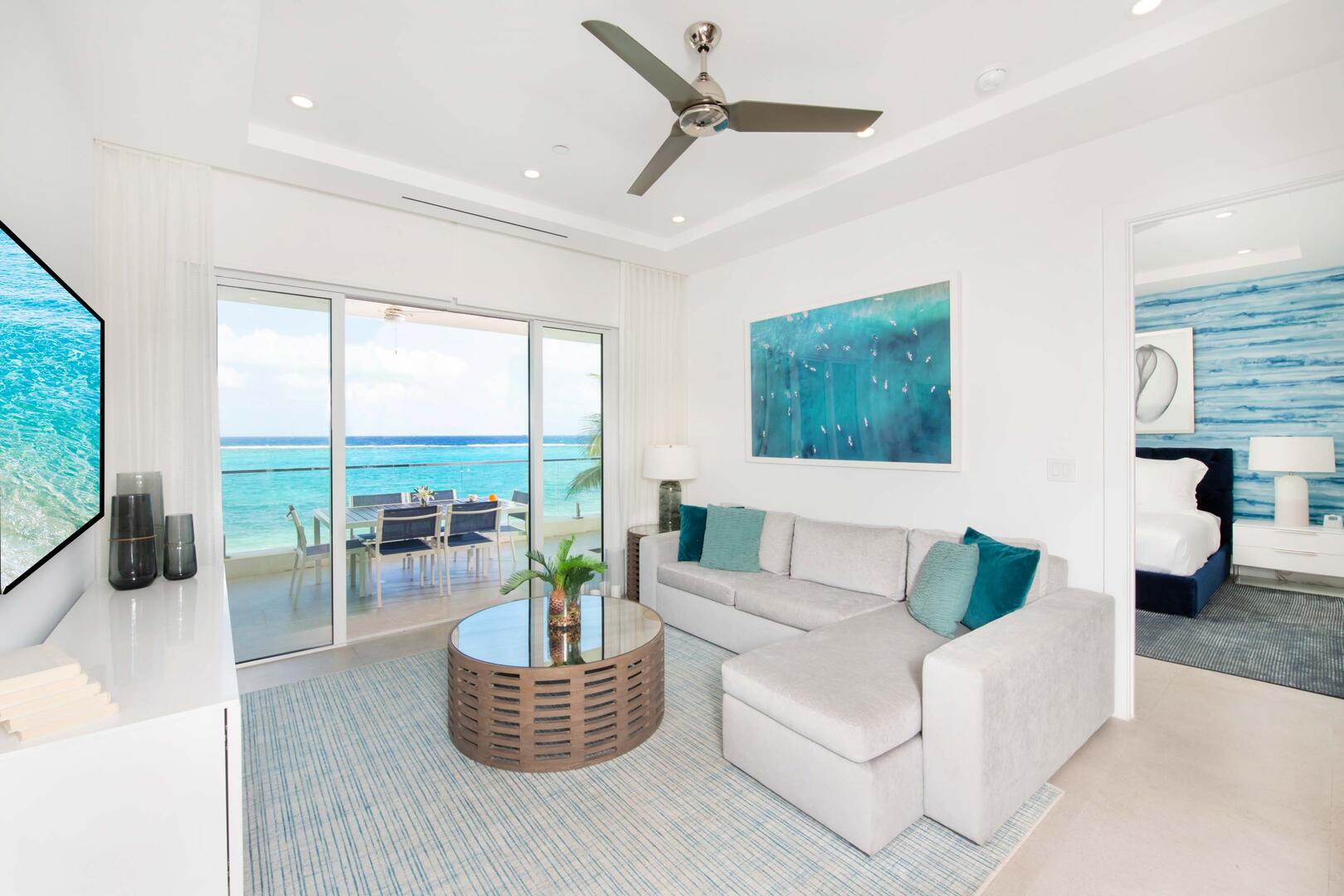 Living area with all the comforts of home: a plush sectional sofa, SmartTV with high-speed wifi, and walk-out access to a private oceanfront balcony.
