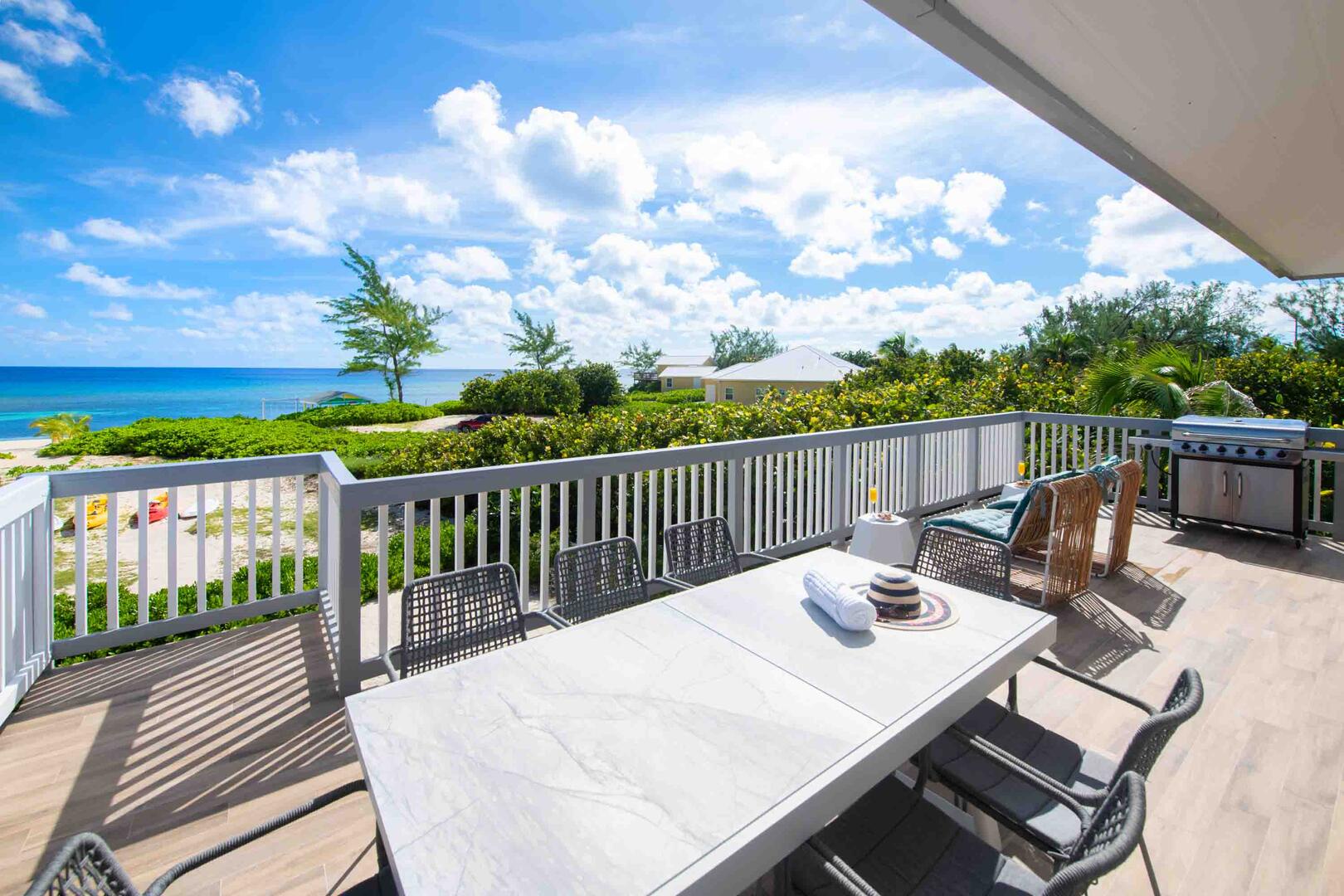 An alfresco dining table sits on the upper deck for meals with seaside views.