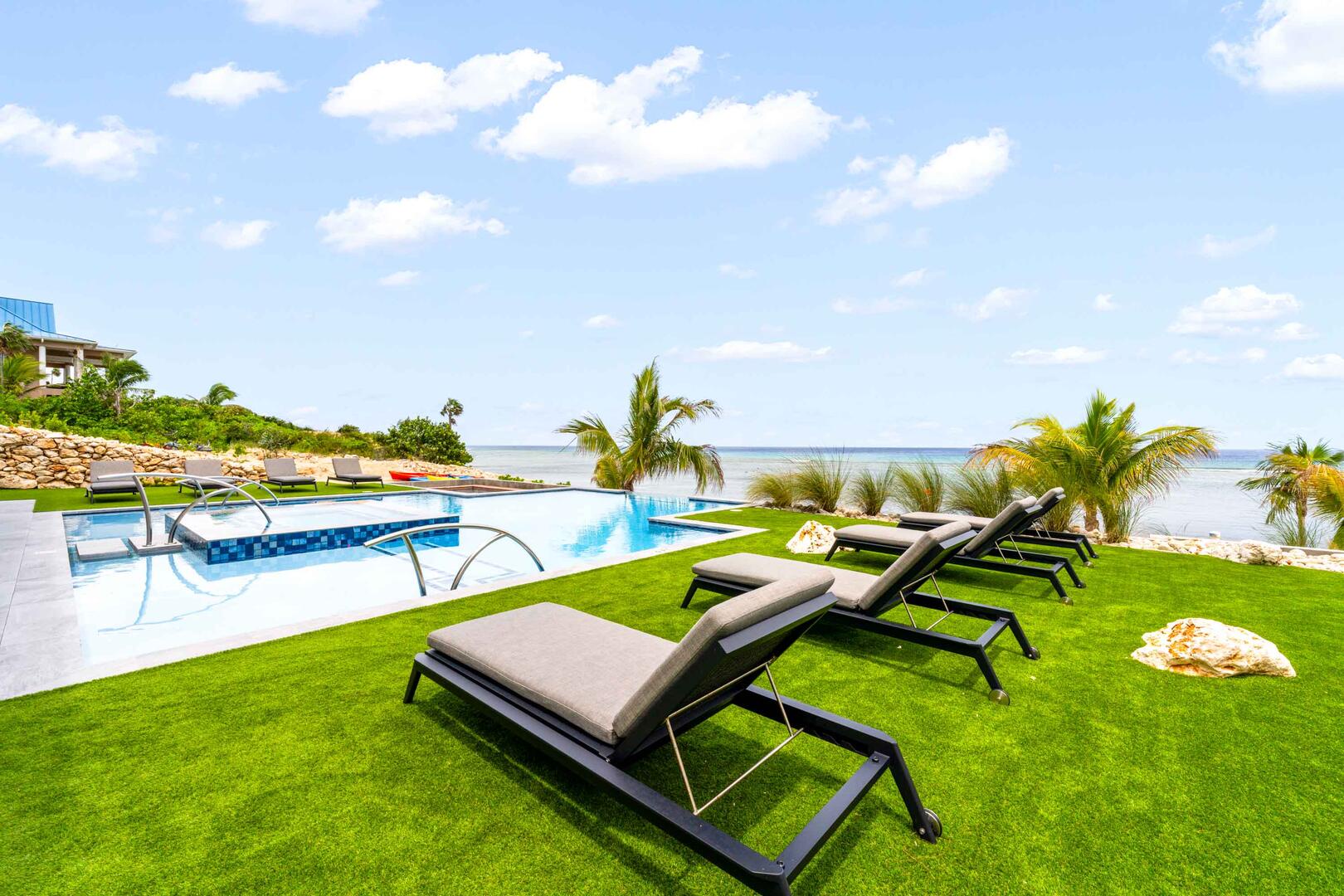 The pool/spa/firepit decks are bordered by synthetic grass lawns