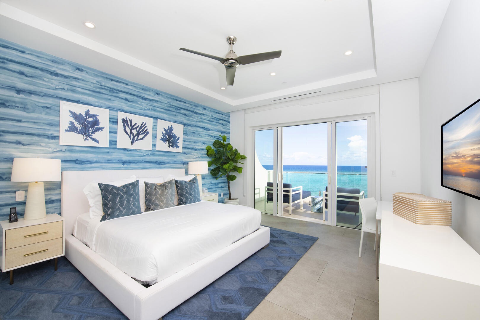 Primary suite with king bed, desk, and ocean views.