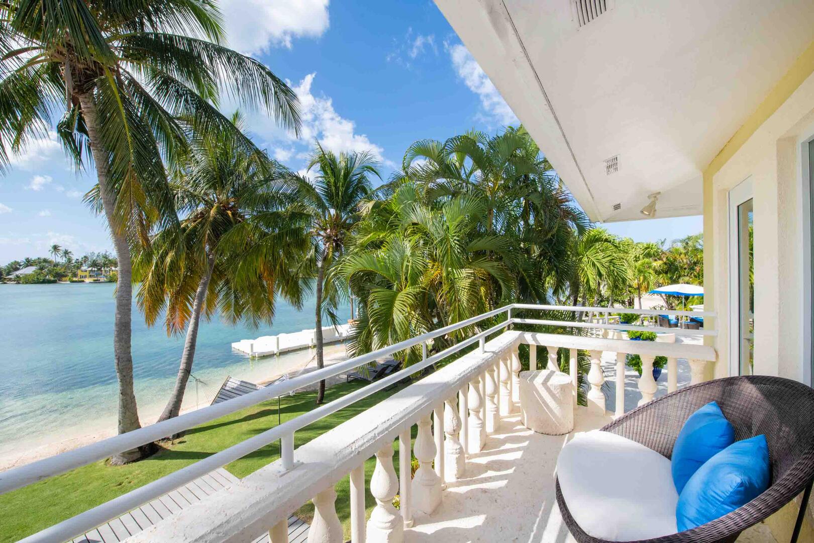 Primary Suite's private balcony with waterfront views and lounge seating.