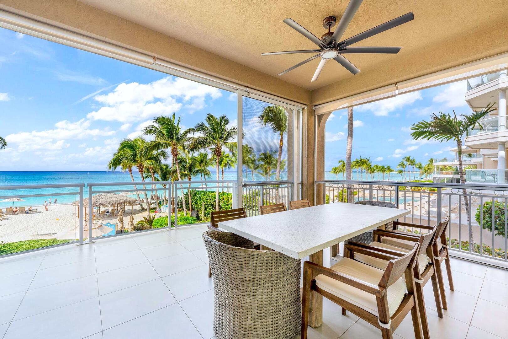 Furnished screened balcony with alfresco dining table for meals with seaside views.