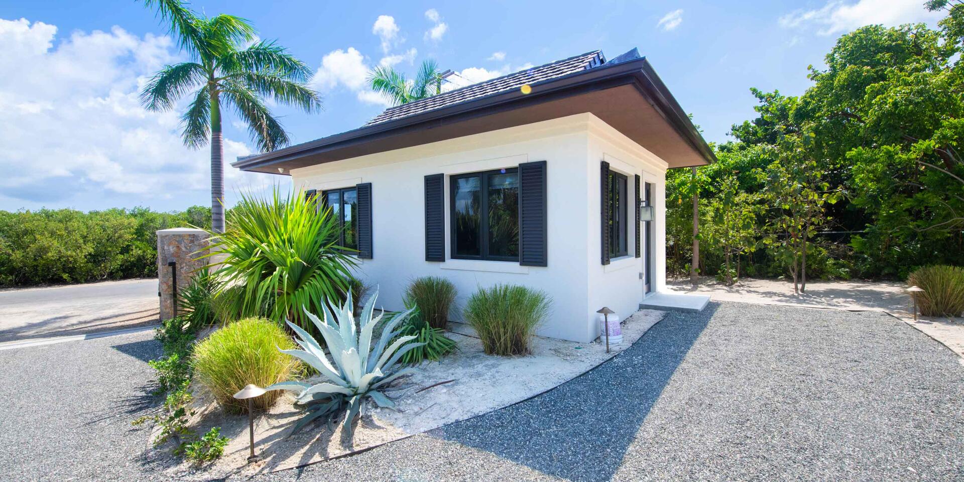 View of the 1-bedroom guesthouse by the gated driveway.