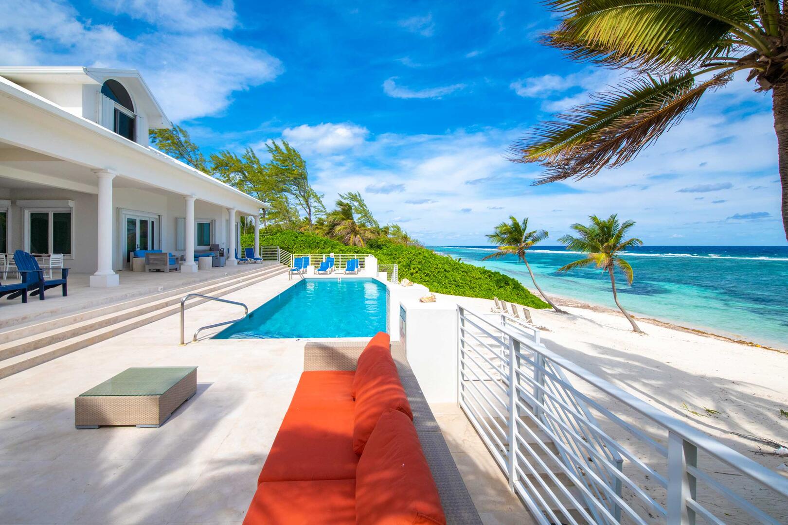 Large pool deck with veranda dining table, sun deck, and sofa lounge.