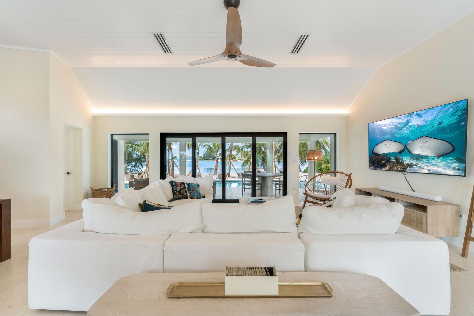 Living area with HD television, sound bar, plush sectional sofa, and waterfront views.