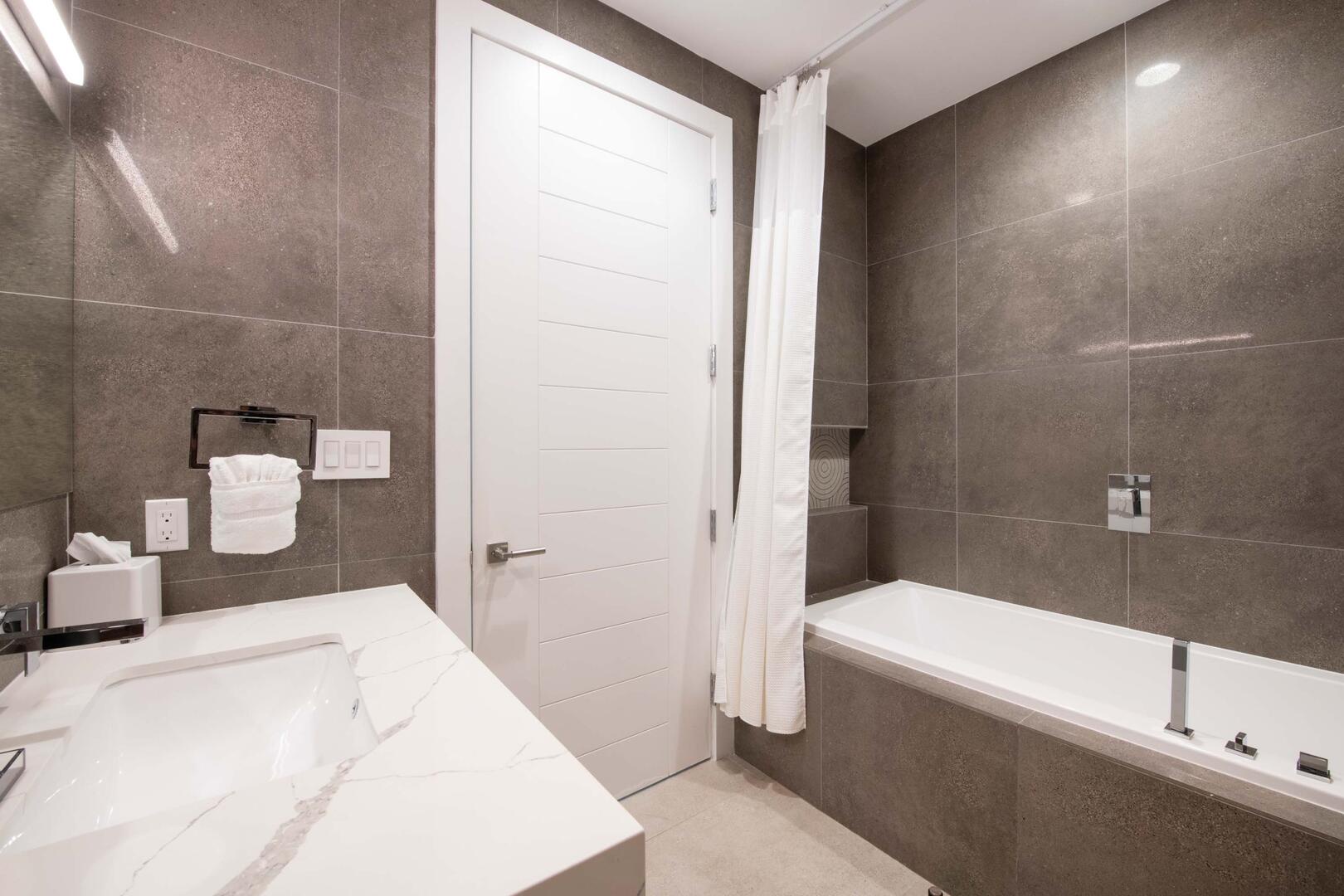 Both guest bedrooms share this adjacent hall bathroom equipped a shower bath.