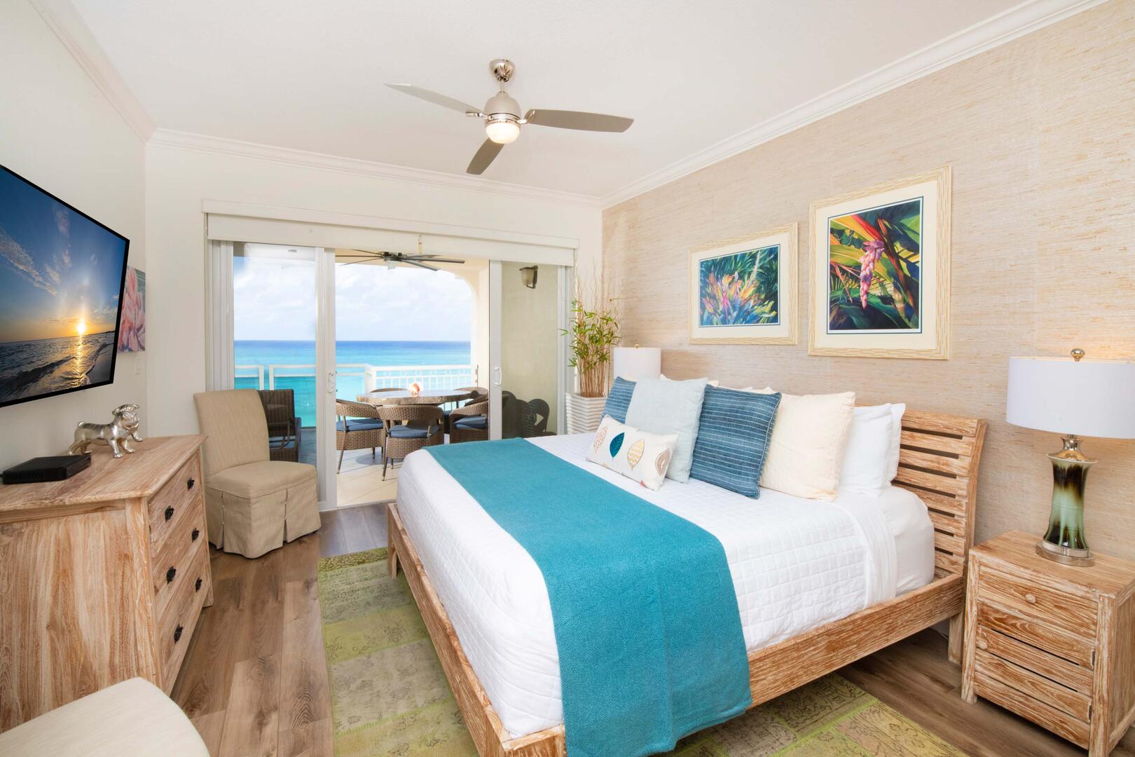 Primary Suite with king bed, television, and walk-out access to the ocean balcony.