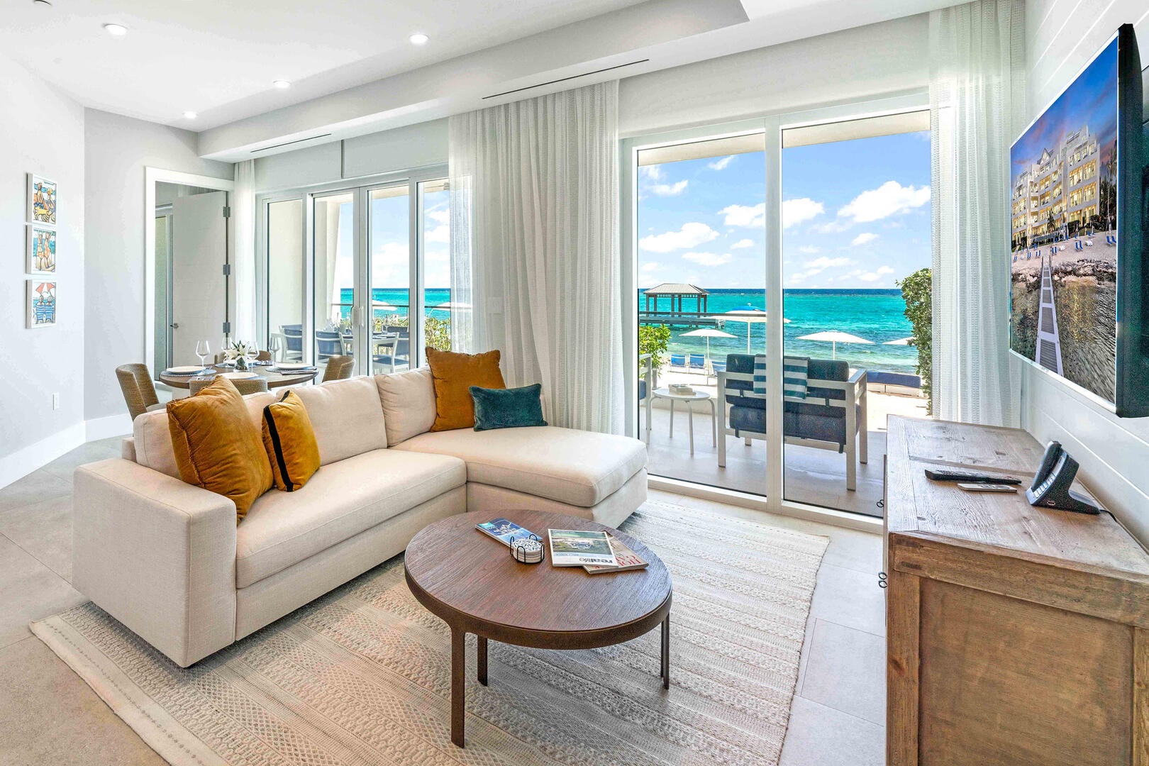 Oceanfront living area with HD television, sectional sofa, and walk-out access to the beach.