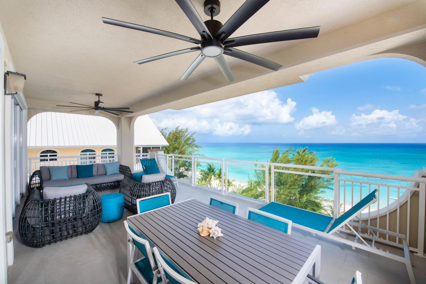 Balcony furnished with lounge furniture and a dining table with seating for 6.