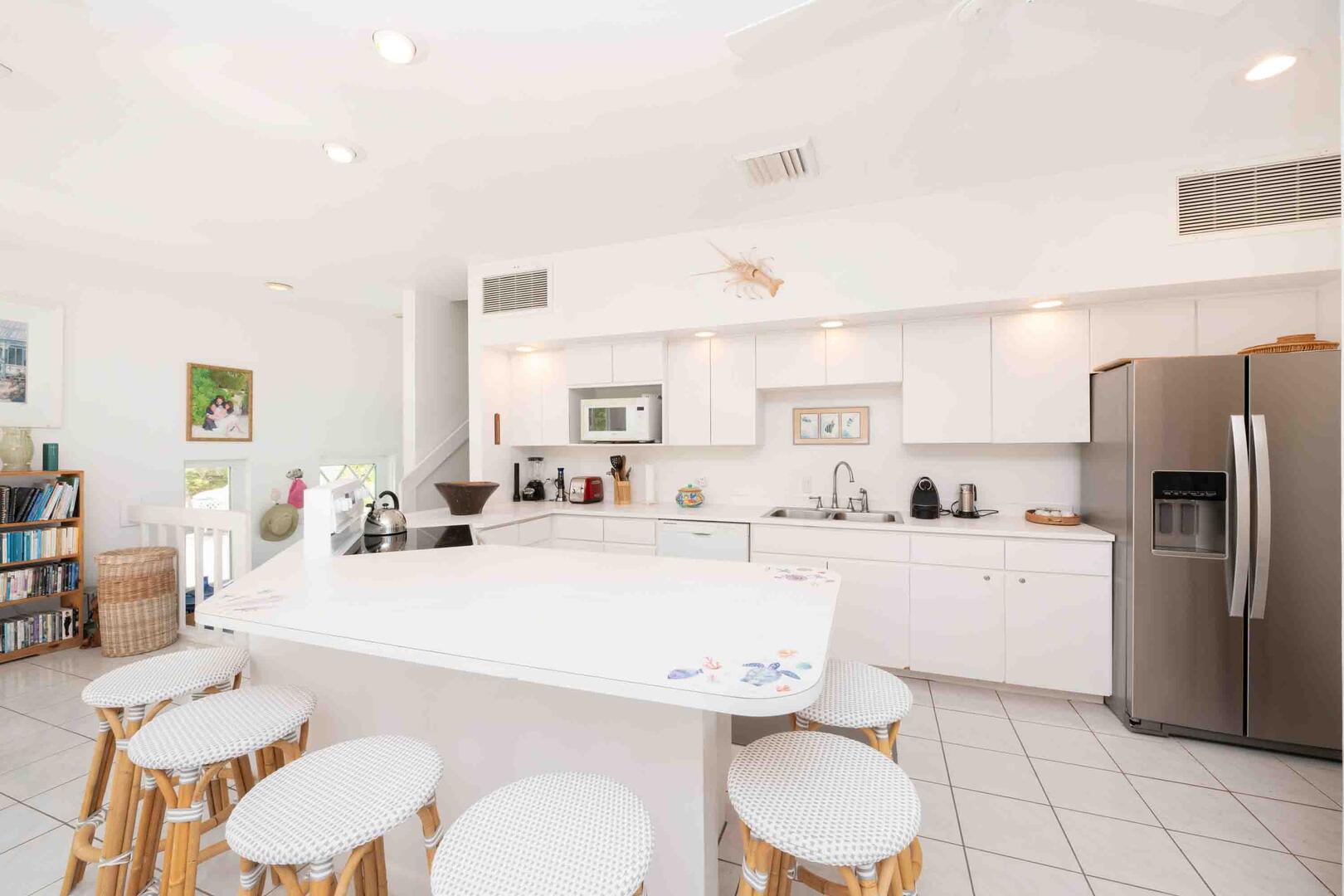 Full kitchen with modern appliances and breakfast bar seating.