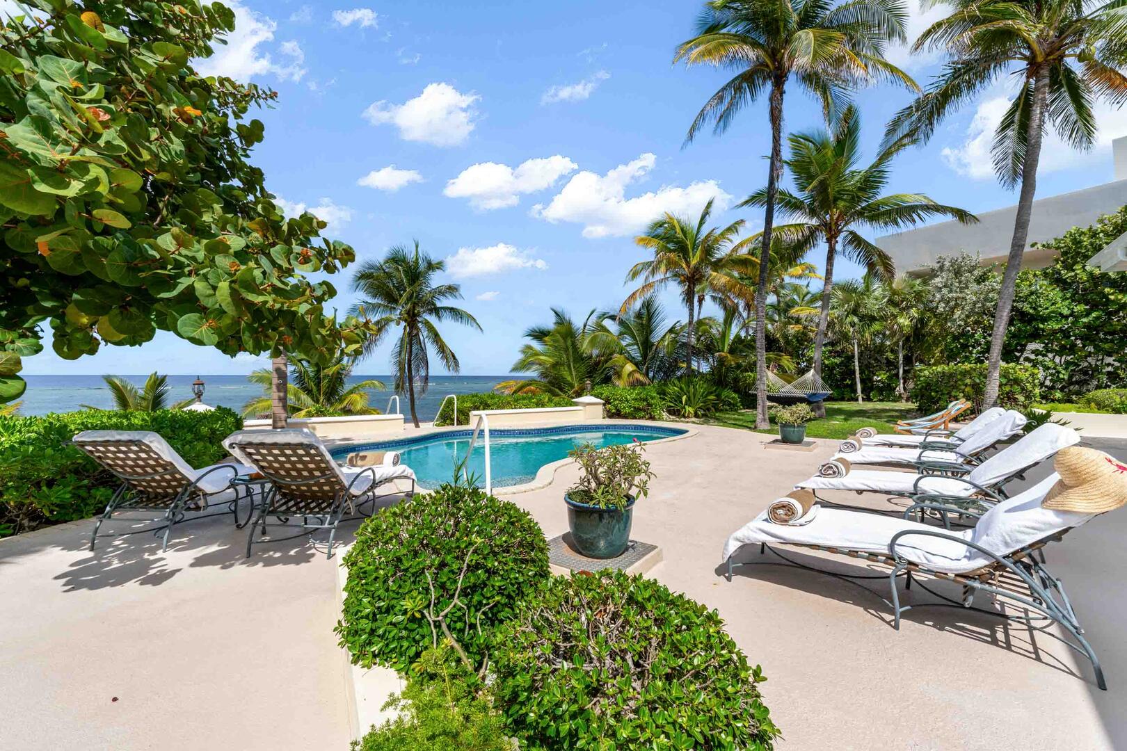 Private pool with sun loungers and ocean views.