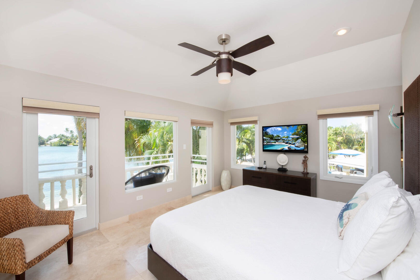 Primary Suite with king bed, television, and walkout access to a private balcony.