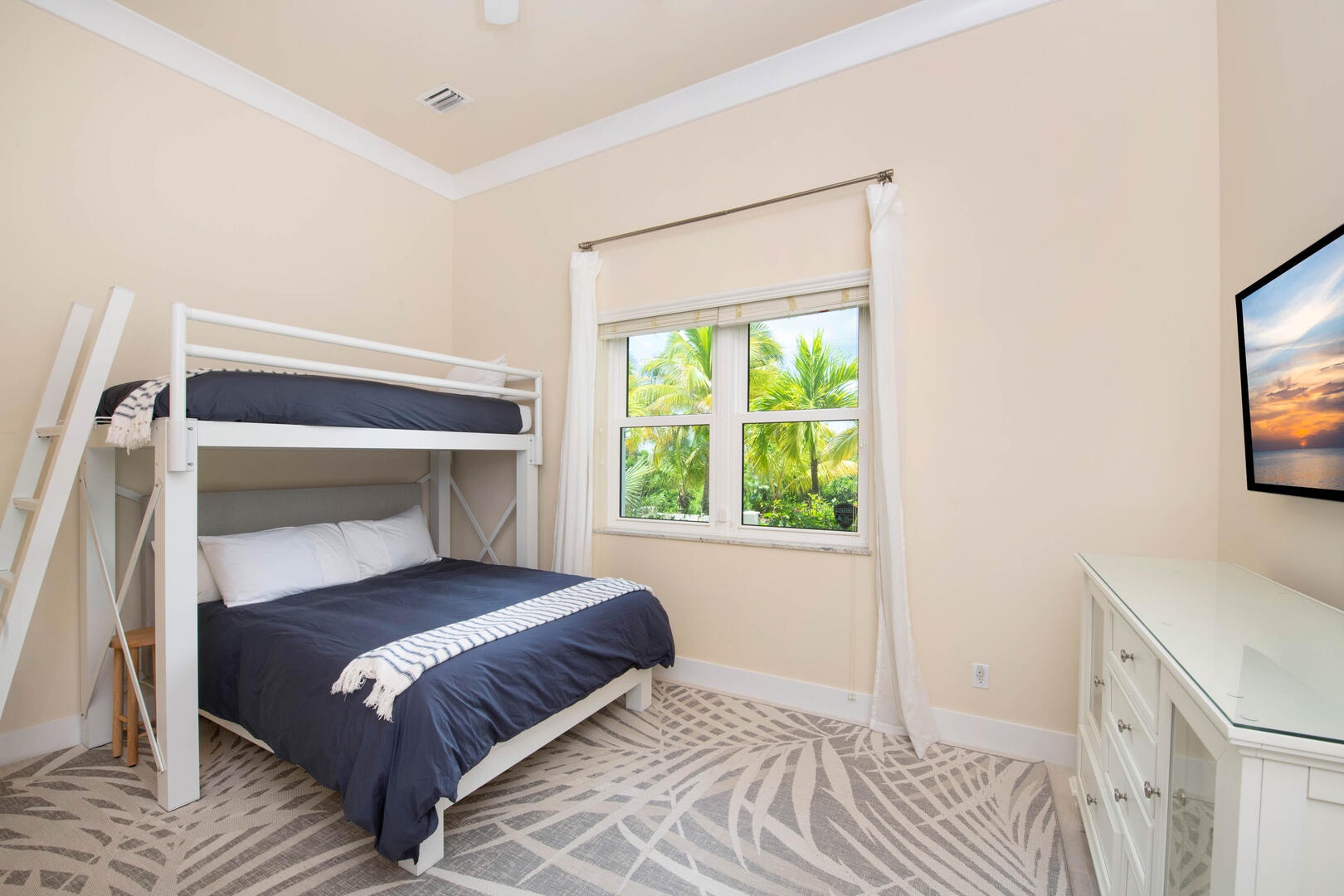 Guest Suite #5 with queen-over-twin bunk beds and television.