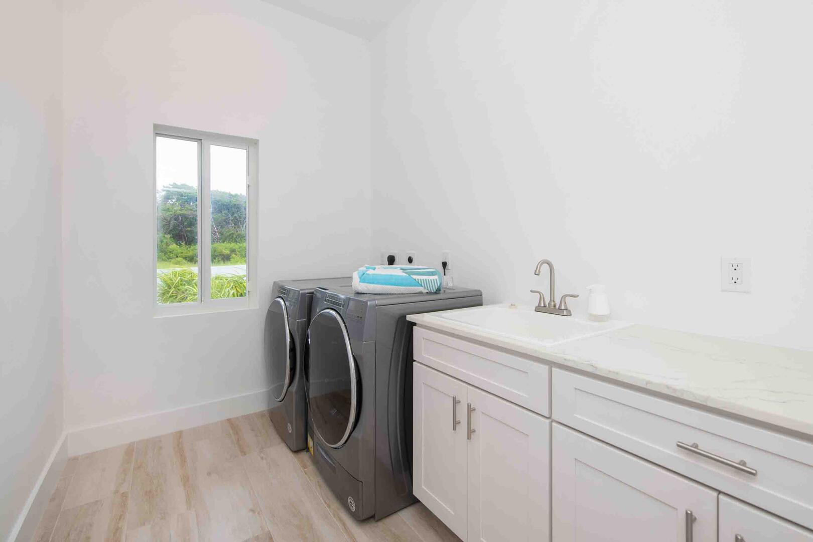 Laundry room with washer, dryer, and utility sink.