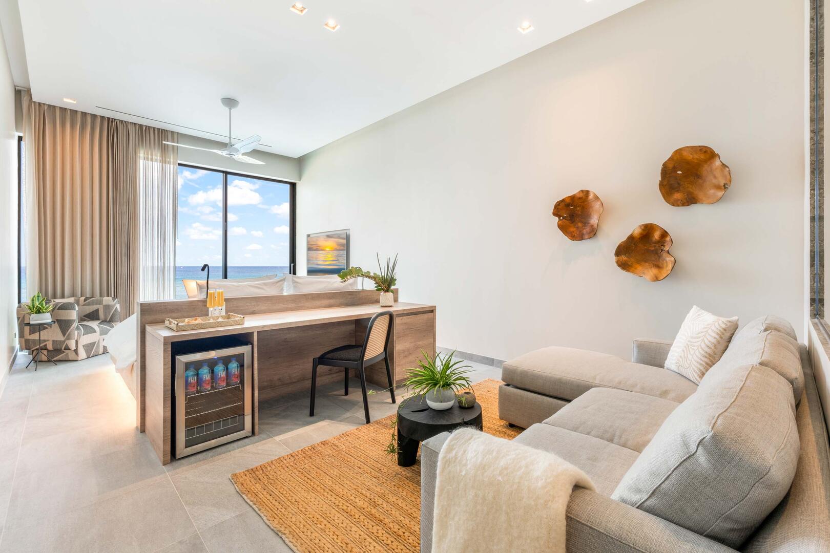 Oceanfront king suite 2 - king platform bed, desk, oceanfront floor-to-ceiling glass doors, 65" TV w/swivel mount, beverage fridge, coffee center, upholstered chair, sofa